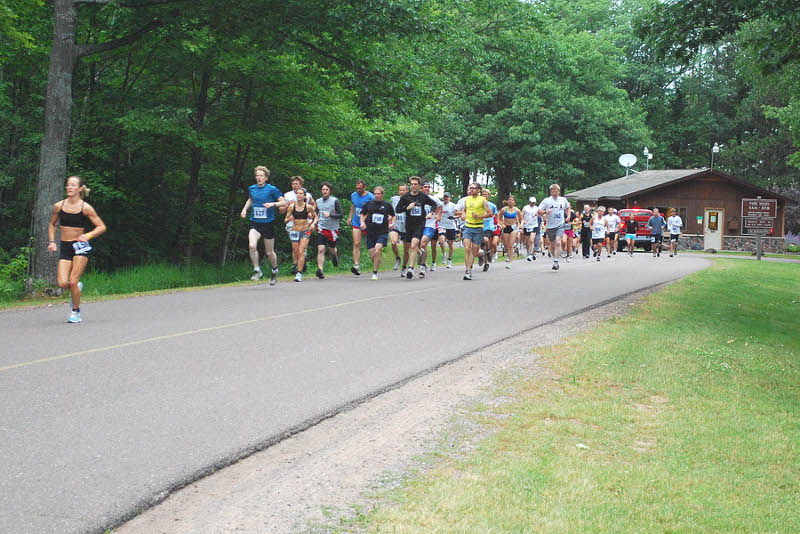 The 10 mile run segment begins bright and early at McLain State Park, north of Hancock, on M203. Here the gun has sounded and the group is off and running.