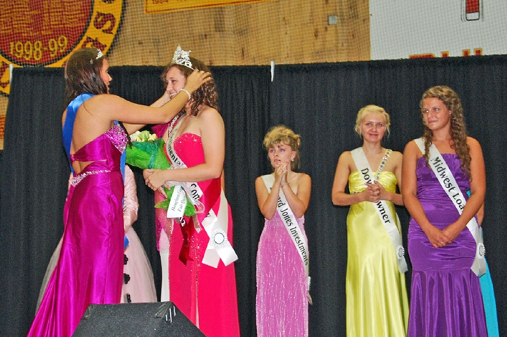 A large field of ten Queen contestants this year vied for the honor. Included was a talent portion, evening gown presentation, and unrehearsed question period. Selected by the judges, as Miss Houghton County Fair Queen, was Megan Godby, 18, of Atlantic Mine, MI. She is being crowned by last year's Queen, Joy Lynn Kinnunen.